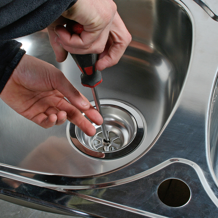 plumber hand close up with screwdriver installing new kitchen sink glenmora la
