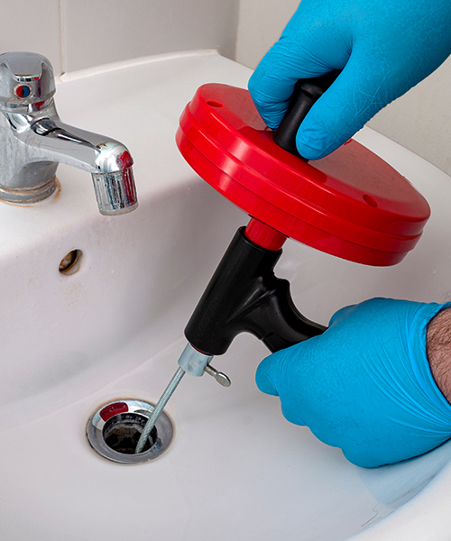plumber hands close up cleaning bathroom sink drain glenmora la